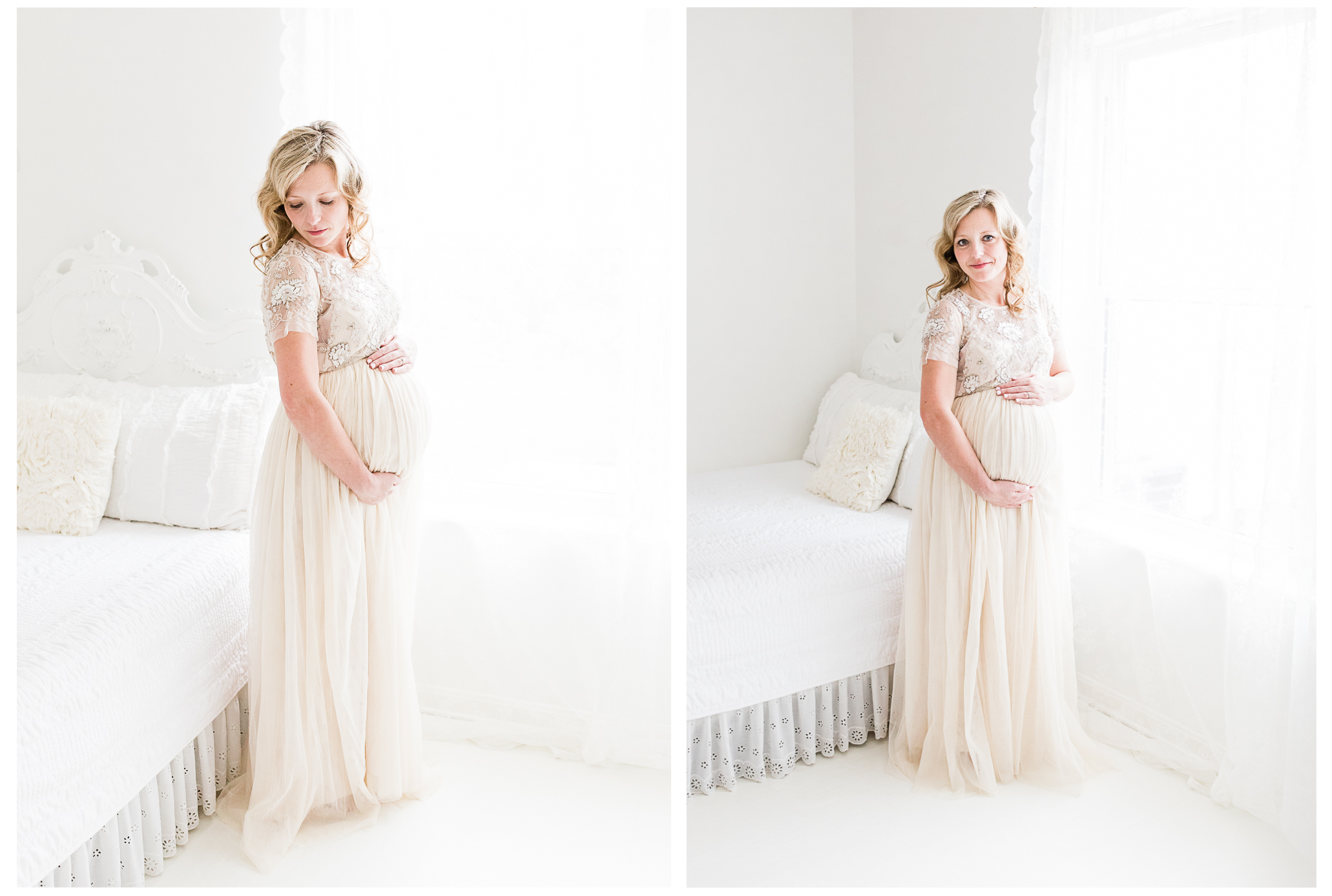 An expecting mother wearing a soft tulle dress smiling in the window light while holding her baby bump