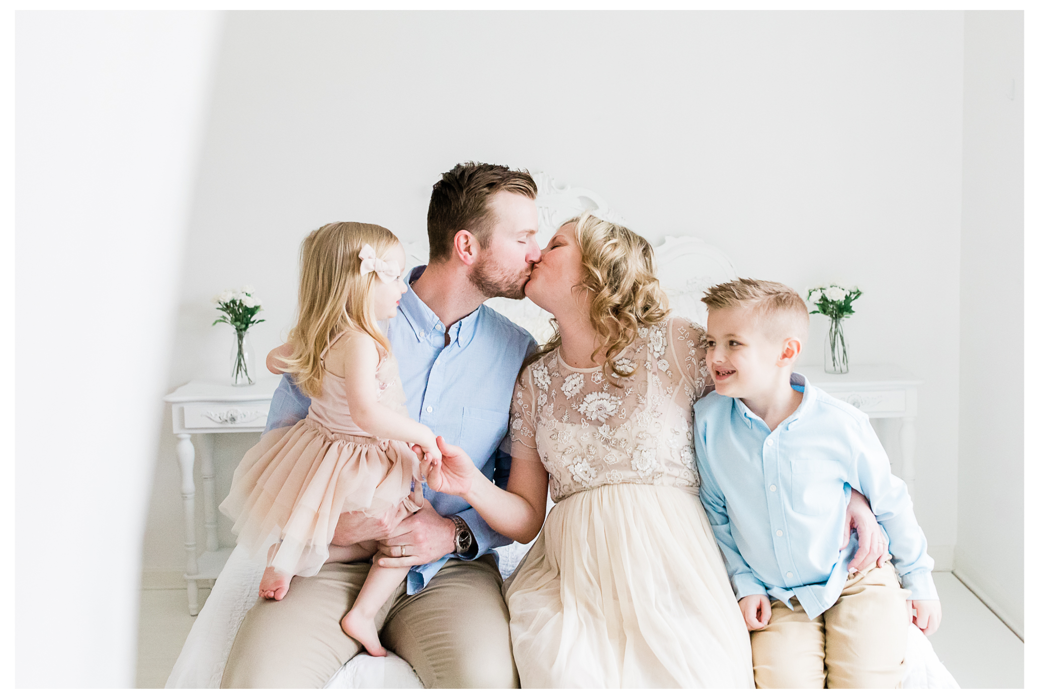 Parents kissing as their two parents watch and smile