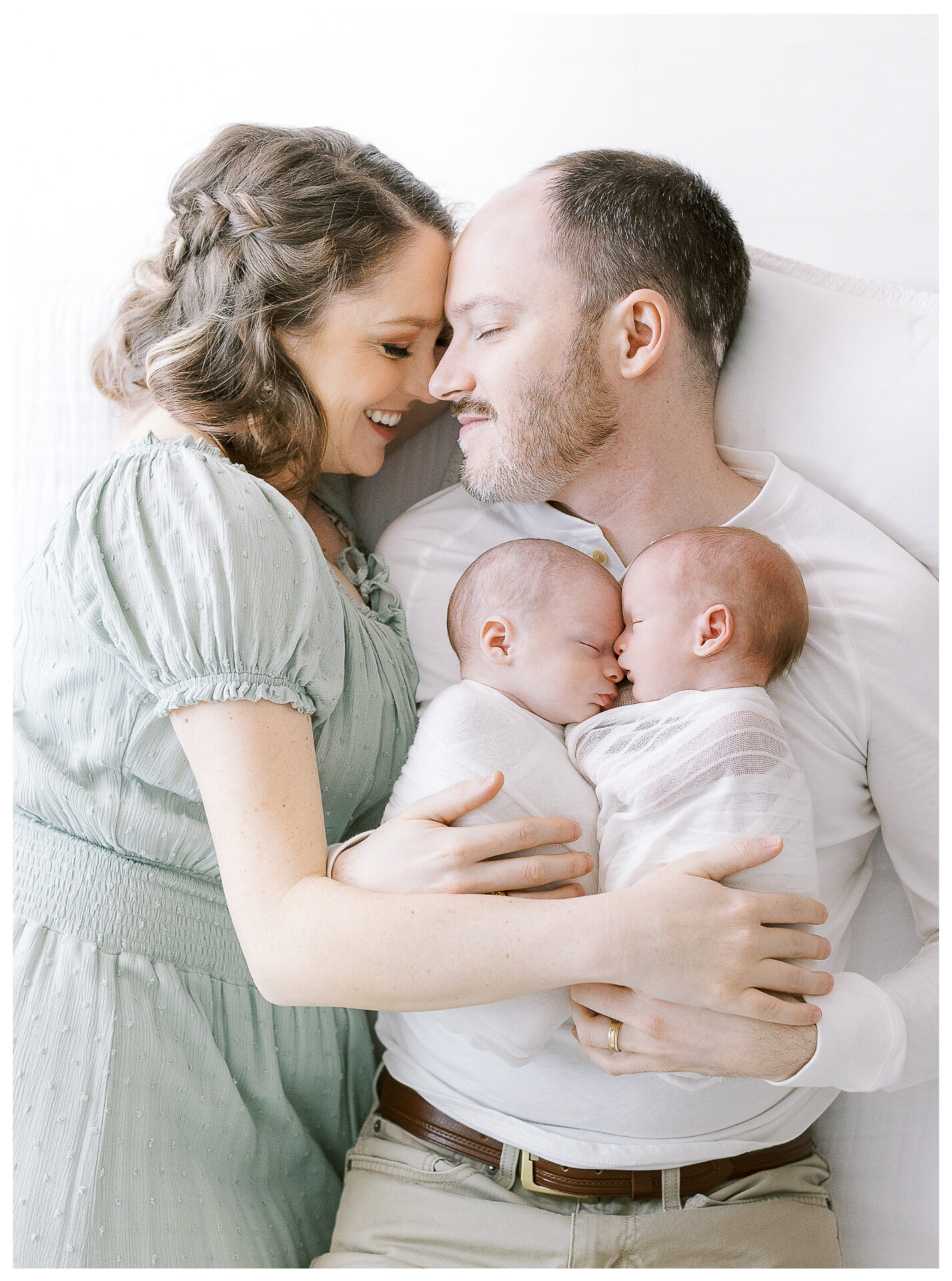 Twin baby boy newborn photography session | Mother and Father laying down, snuggling their babies