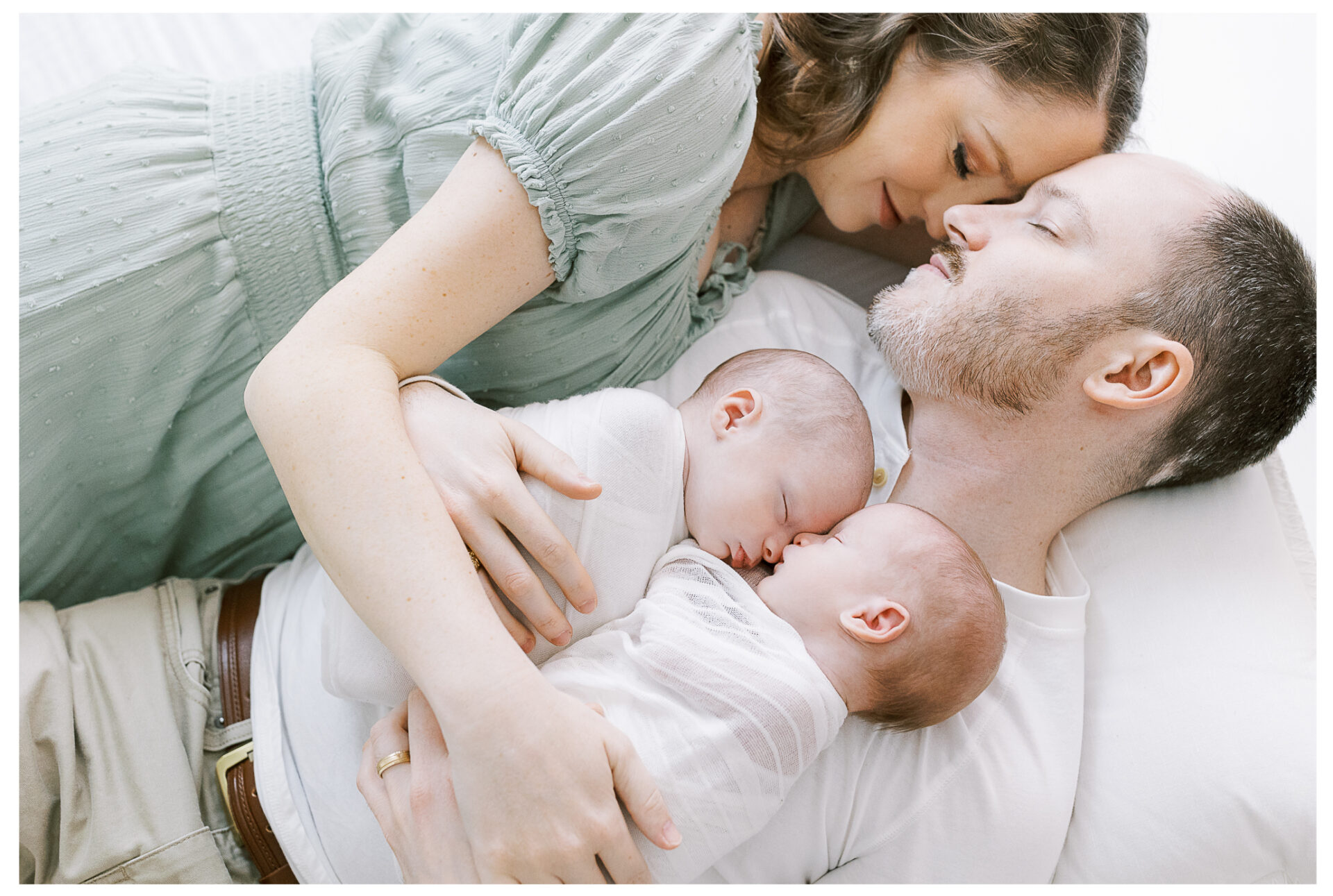Twin baby boy newborn photography session | Mother and Father laying down, snuggling their babies