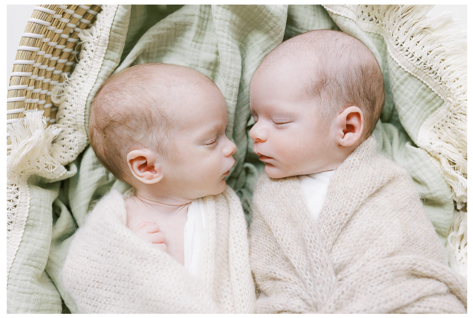Newborn baby boys swaddled and snuggled together in a cozy basket sleeping | Twin newborn sessions are extra sweet because the bond between womb-mates encompasses the most beautiful organic connection, one that starts from the very beginning and lasts a lifetime.