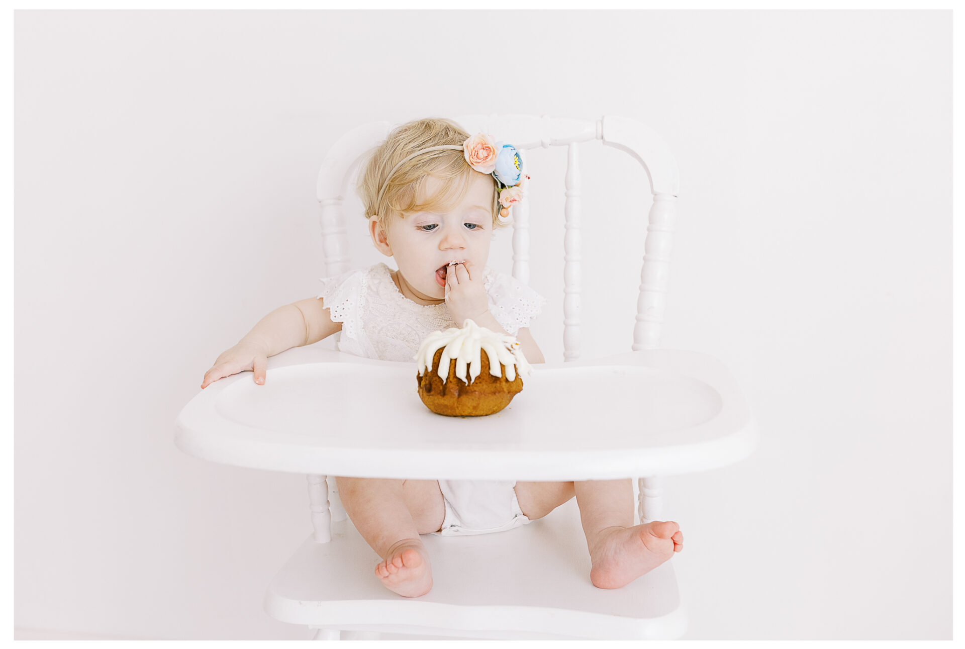 Winter Freire Photography | First birthday photos for baby girl in a photography studio eating her smash cake