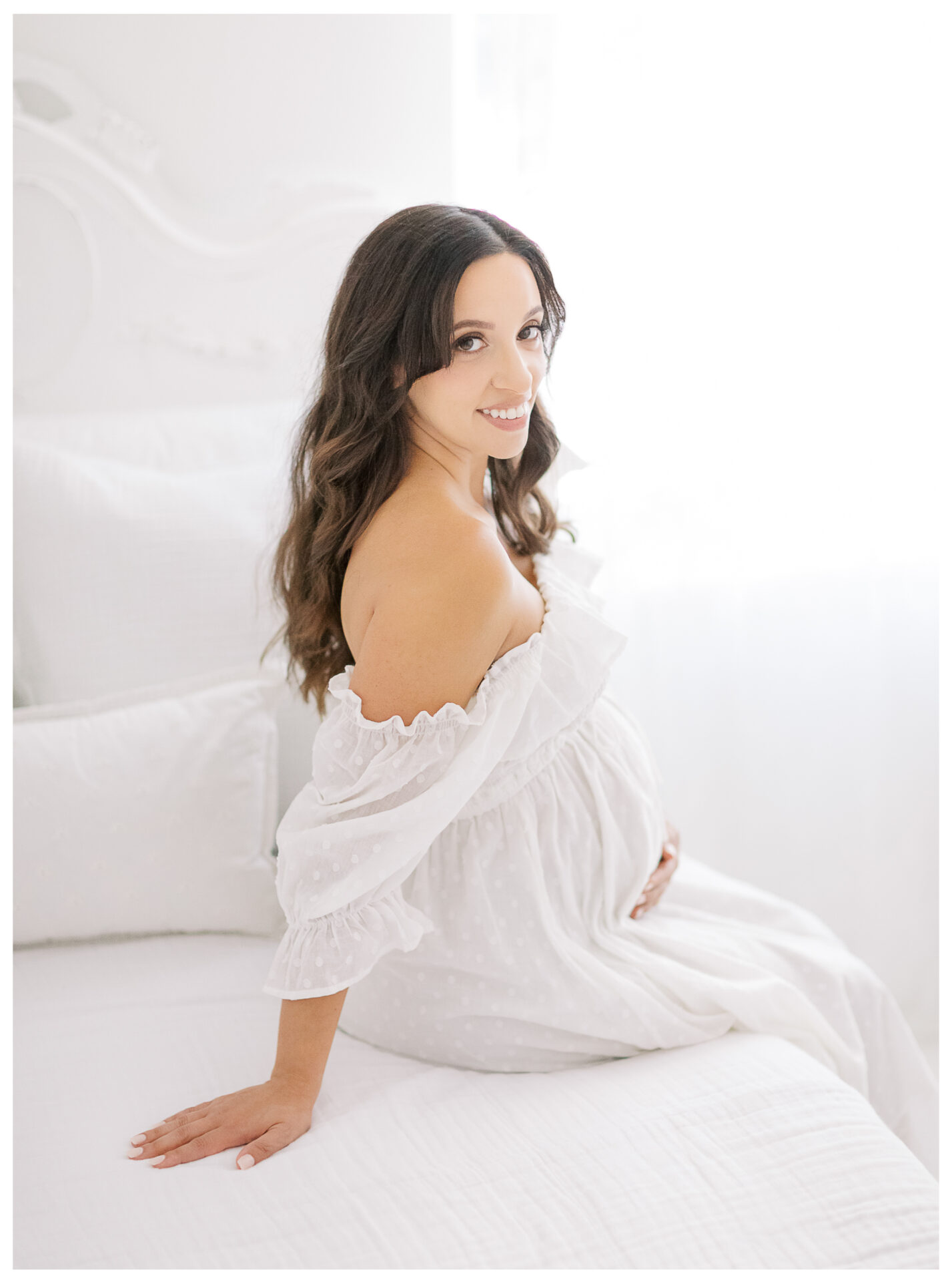 Winter Freire Photography | Natural Light Studio Maternity Session in Dayton, OH | Mama-to-be holding her baby bump in a smocked white dress