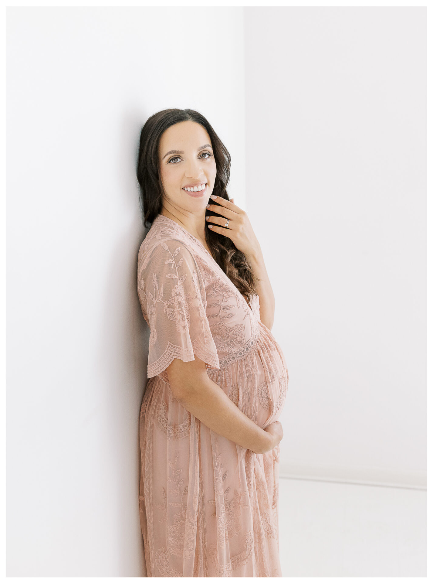 Winter Freire Photography | Natural Light Studio Maternity Session in Dayton, OH | Mama-to-be holding her baby bump in a pink lace dress