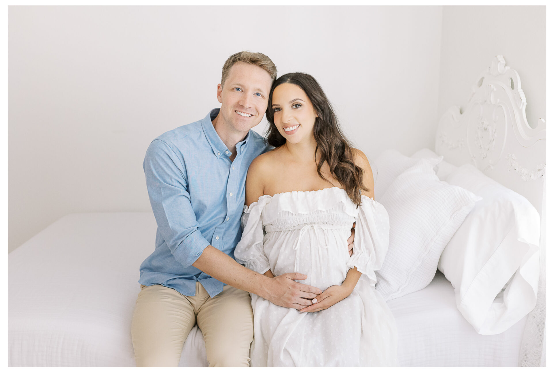 Winter Freire Photography | Natural Light Studio Maternity Session in Dayton, OH | Mama-to-be and husband smiling together with their hands on the baby bump