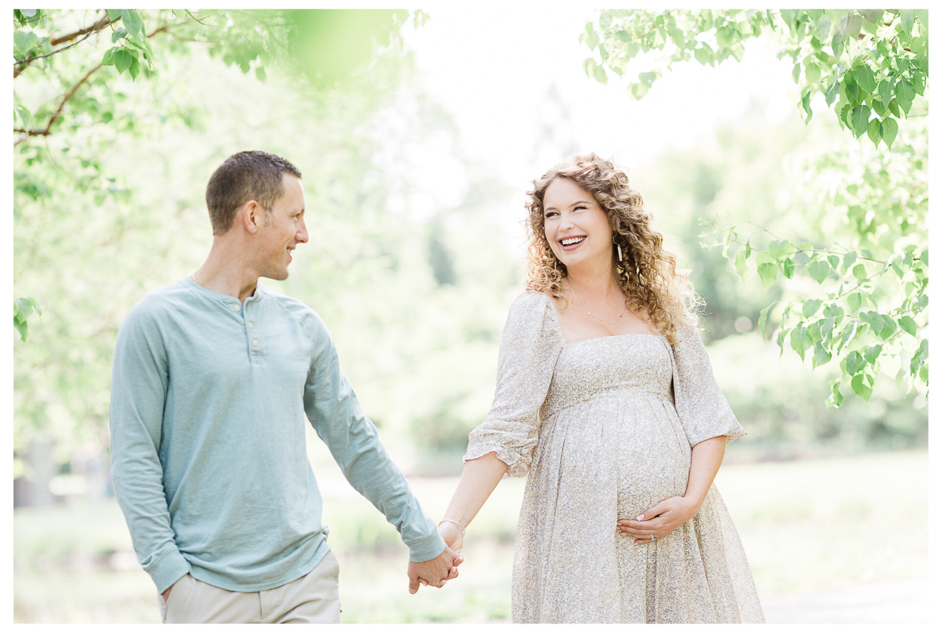 Winter Freire Photography | husband and wife standing on a path holding hands and smiling together during their outdoor maternity session