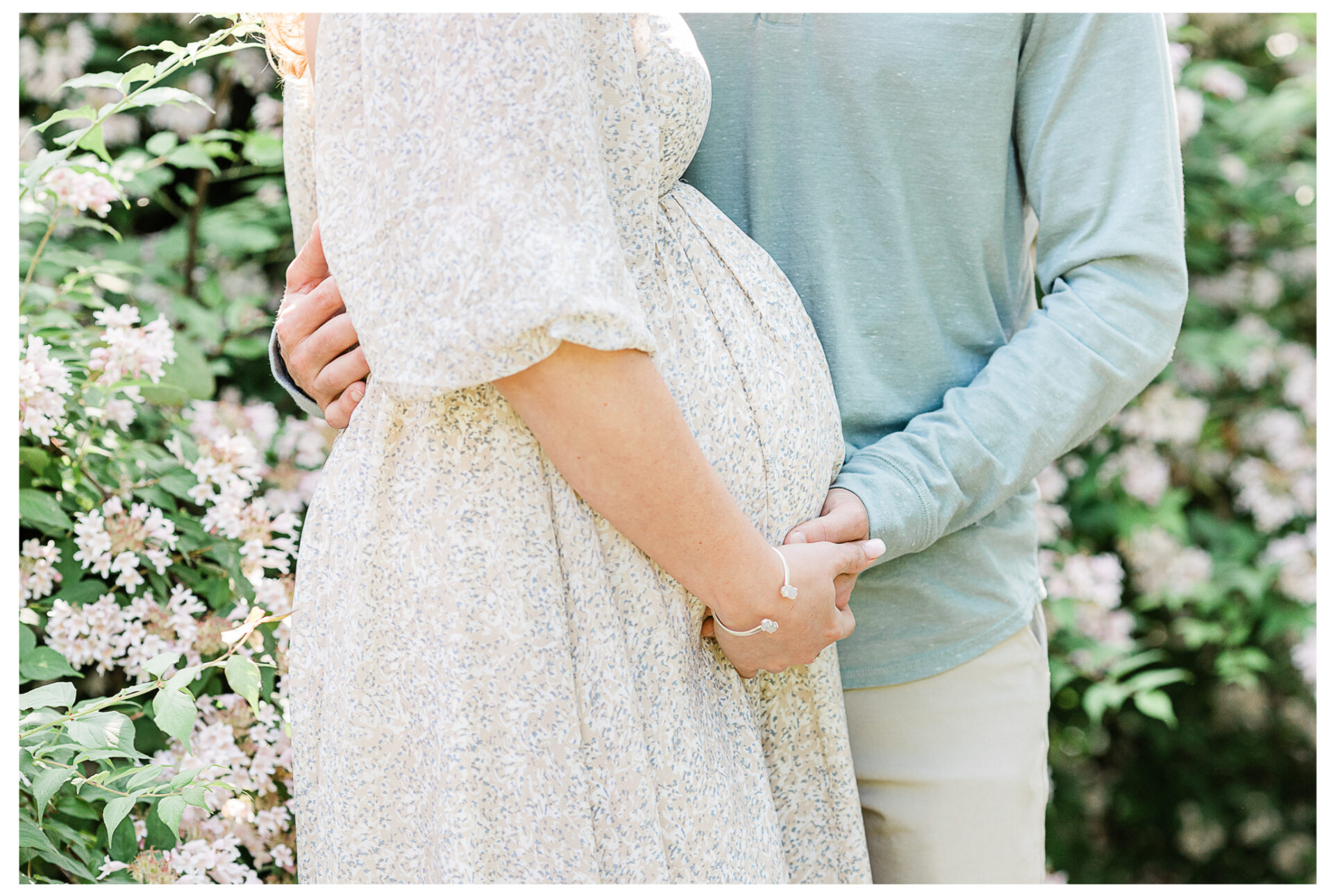 Winter Freire Photography | maternity session outdoors | a close cropped image of the couple's hands on the baby bump
