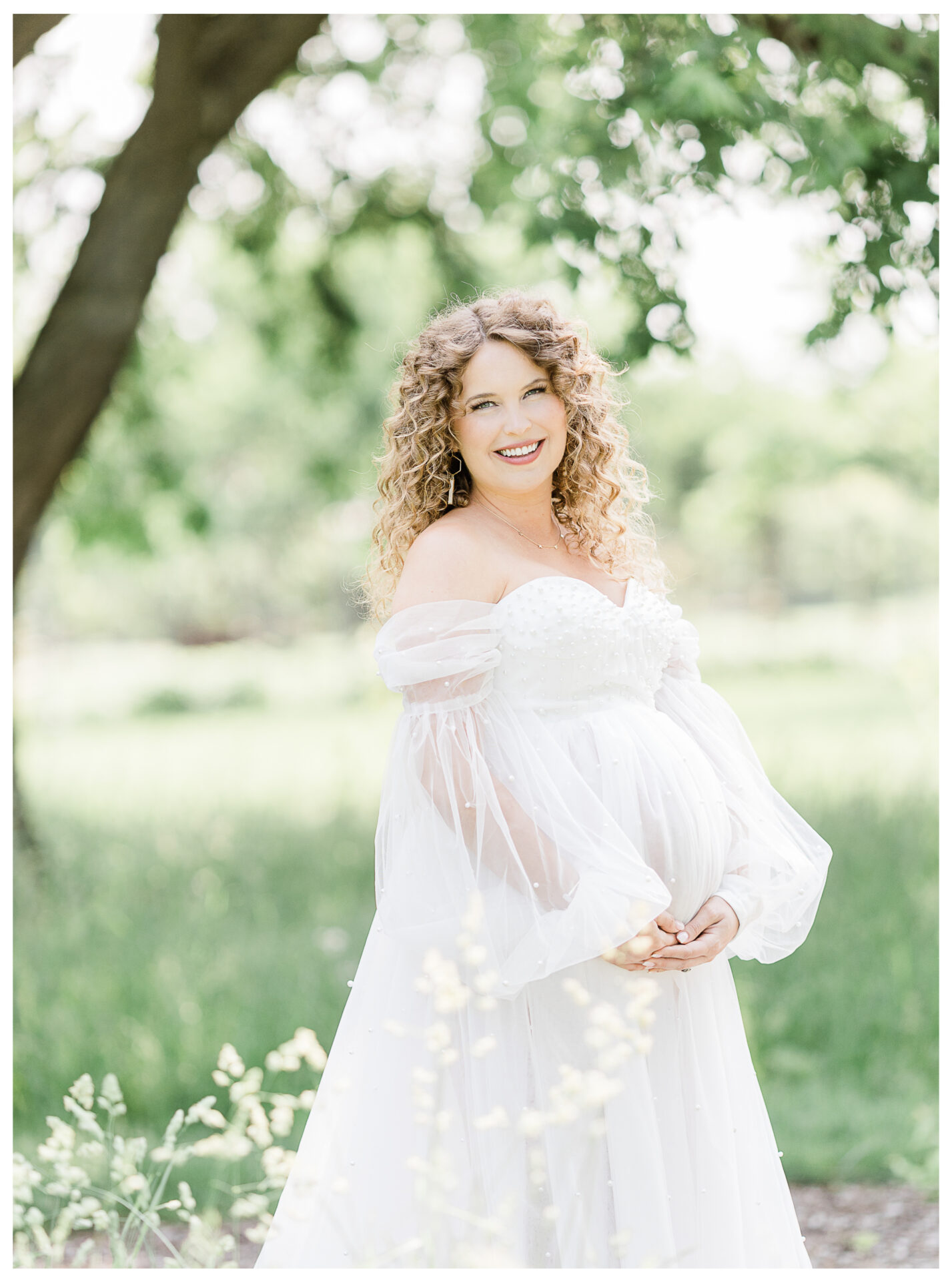 Winter Freire Photography | maternity session outdoors | woman smiling as she is holding her baby bump