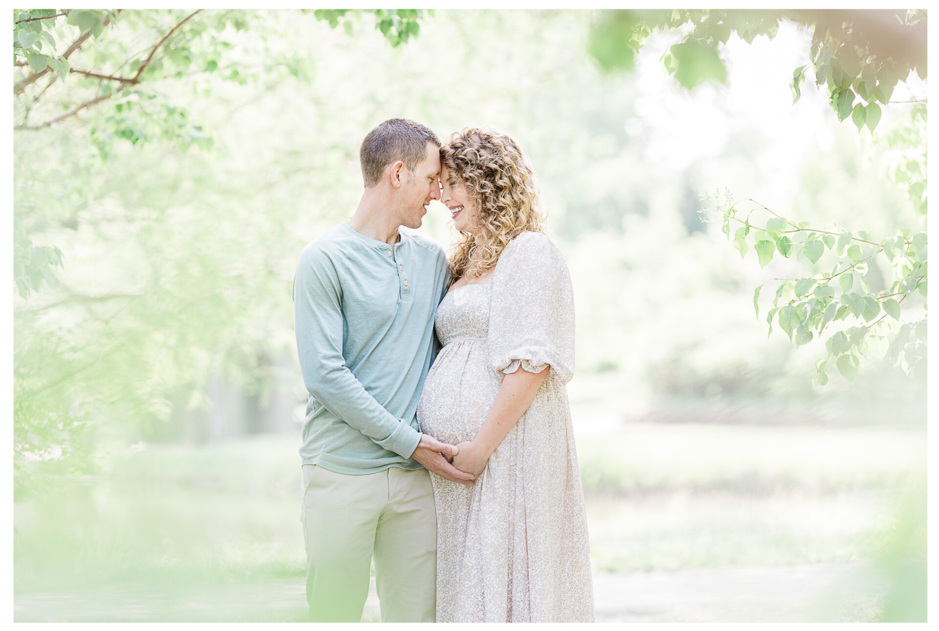 Winter Freire Photography | maternity session outdoors | husband and wife smiling together while placing their hands on the baby bump