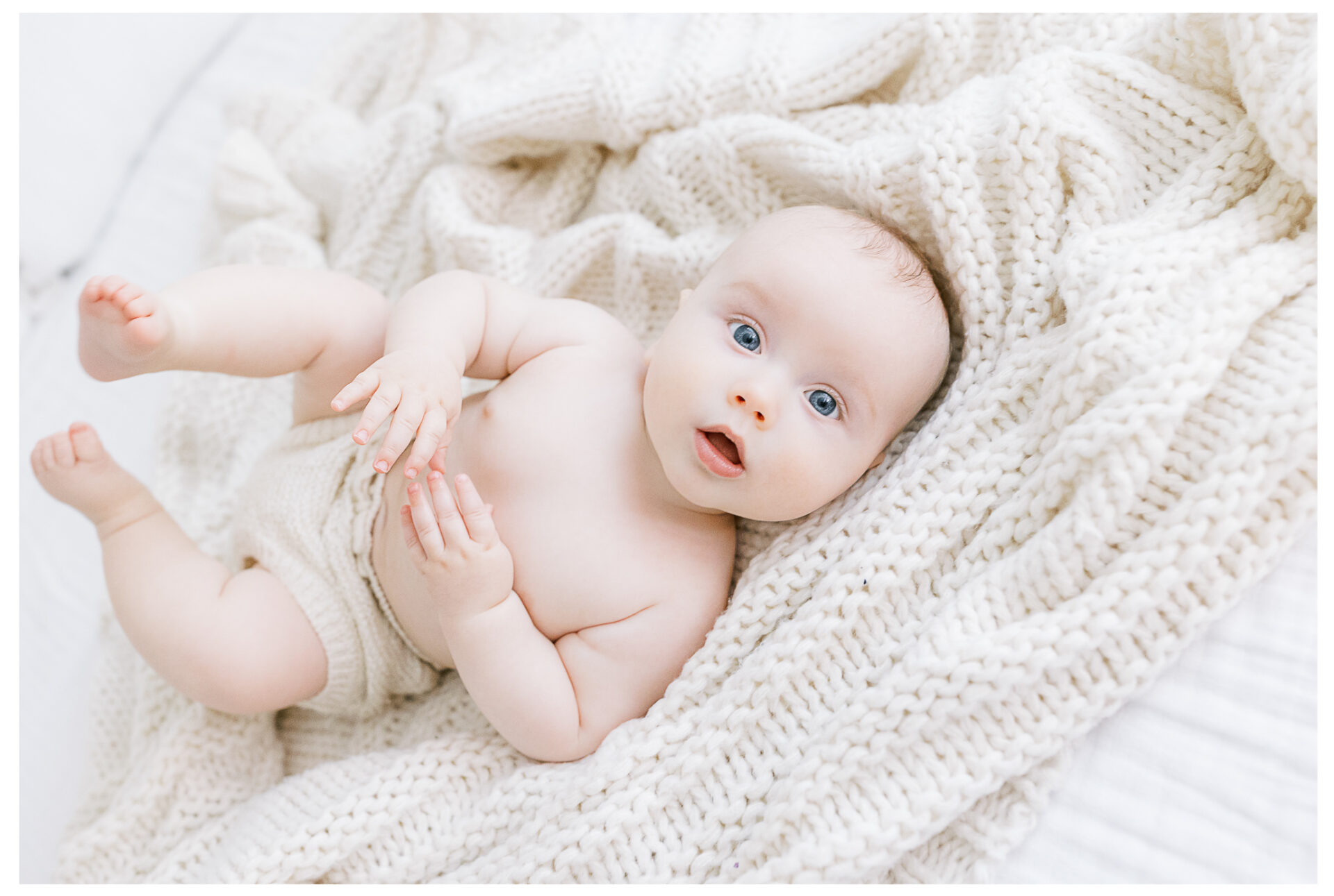 Winter Freire Photography | Dayton, Ohio Baby Milestone Session | Organic Family Studio Photography | 6 Month old baby laying on a white bedspread