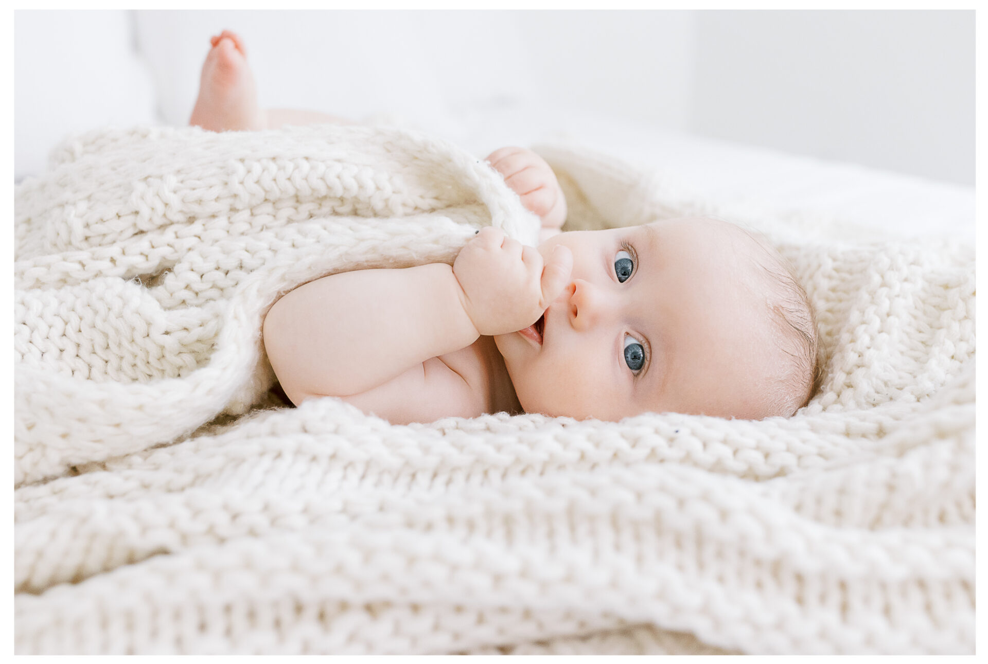 Winter Freire Photography | Dayton, Ohio Baby Milestone Session | Organic Family Studio Photography | 6 Month old baby sucking his thumb while snuggling a blanket