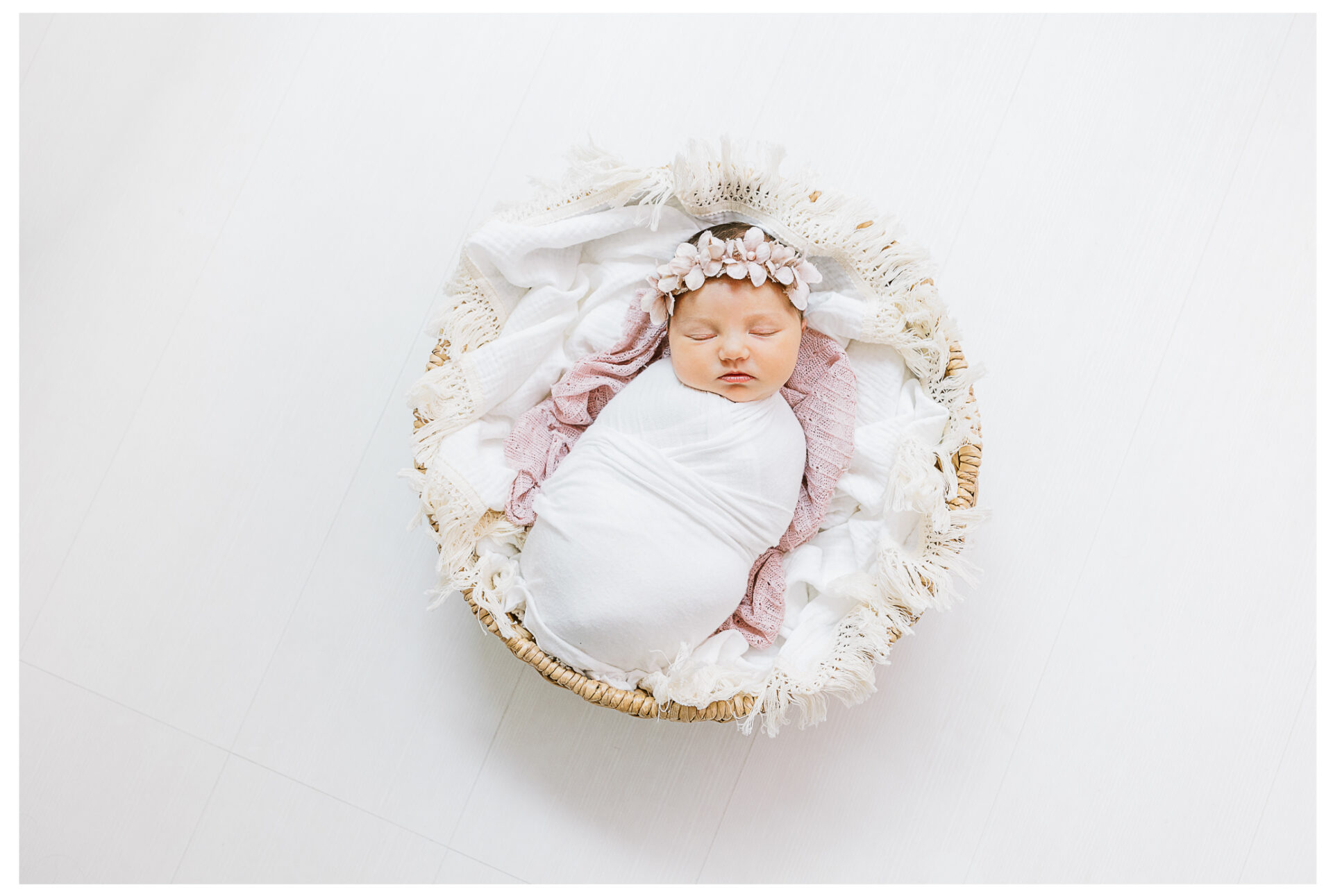 Winter Freire Photography | Dayton, Ohio Newborn Session | Newborn baby girl portraits laying in a basket asleep while wearing a floral headband