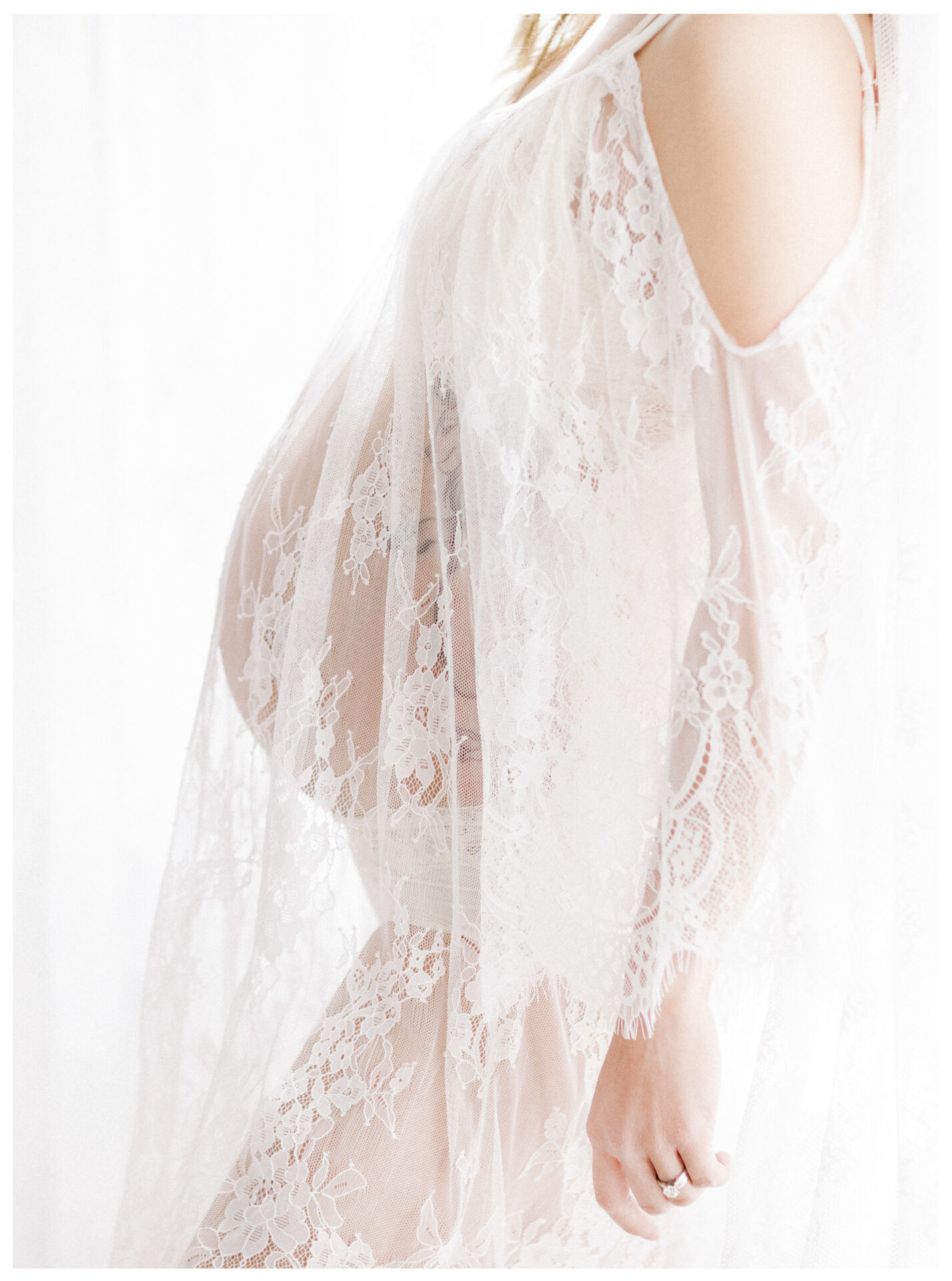 Winter Freire Photography | Fine Art Maternity Boudoir | Expecting mother wearing a sheer lace dress by the window light