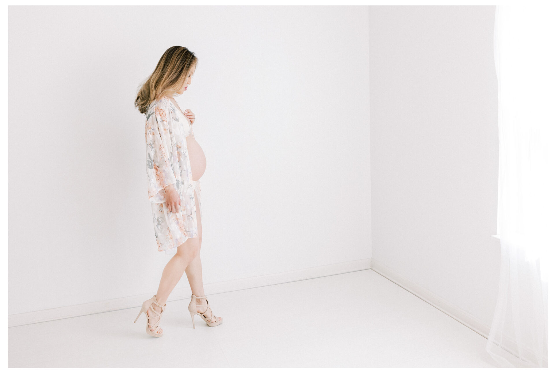 Winter Freire Photography | Fine Art Maternity Boudoir | Expecting mother walking in high heels while wearing a floral robe