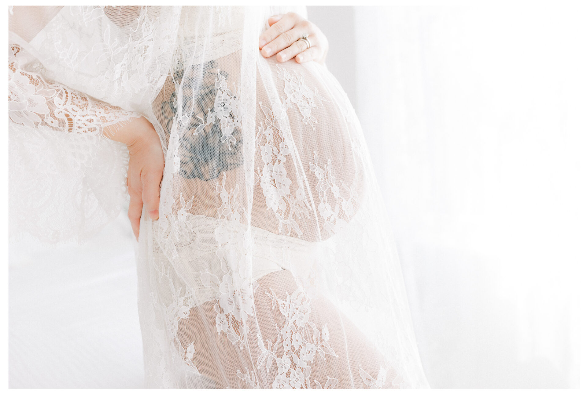 Winter Freire Photography | Fine Art Maternity Boudoir | A close image of an expecting mother's baby bump while wearing a sheer lace dress