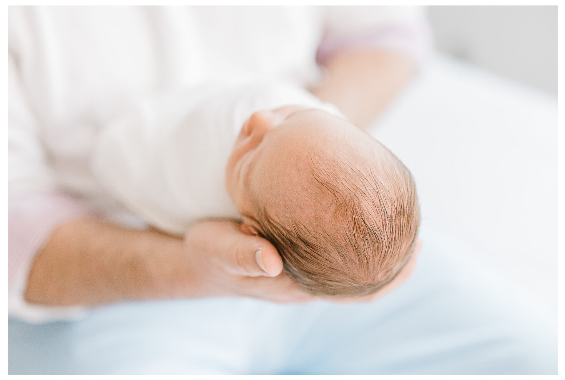 A close up of a newborn's light golden hair.